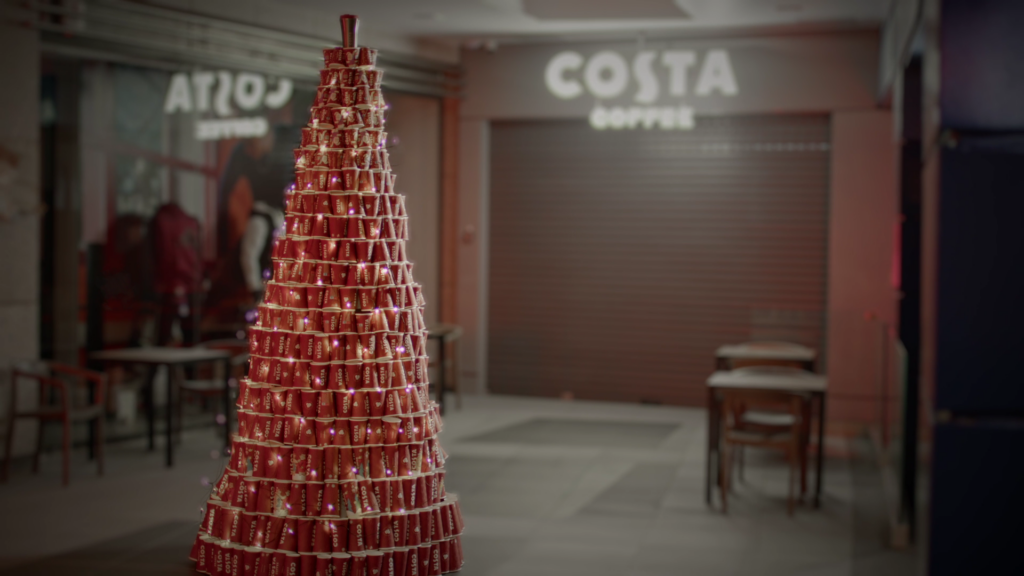 a lit up christmas tree made from disposable costa coffee cups